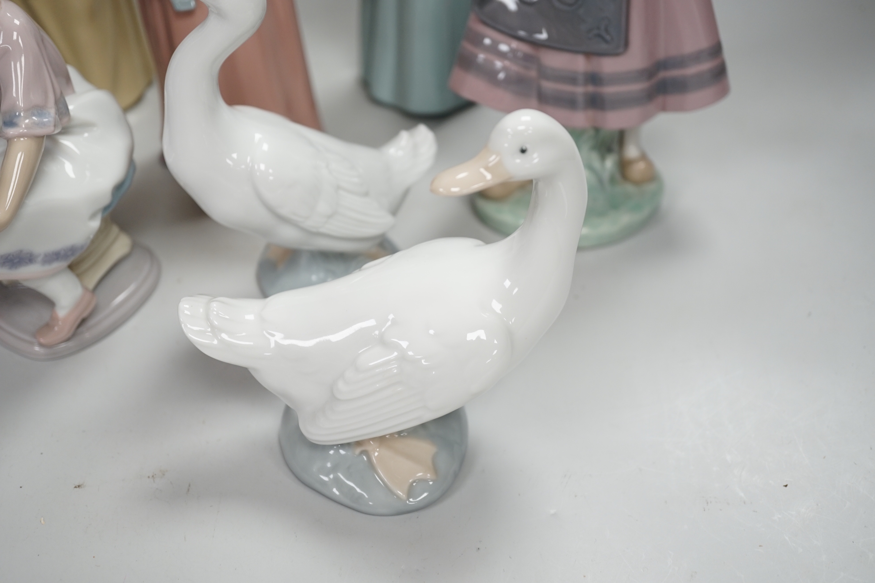 Six Lladro figures of girls, three with hats, one with a Teddy, two peasant girls with flowers and two Nao ducks, the largest 26cm high (8)